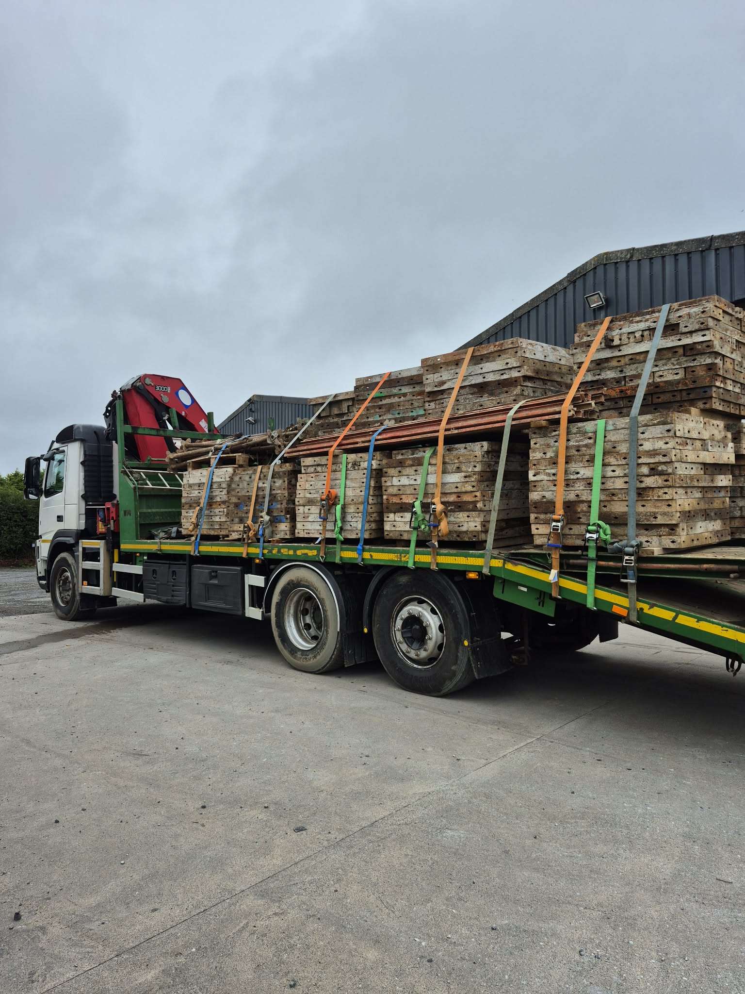 The beavertail lorry loaded and strapped down, with the crane folded behind the cab