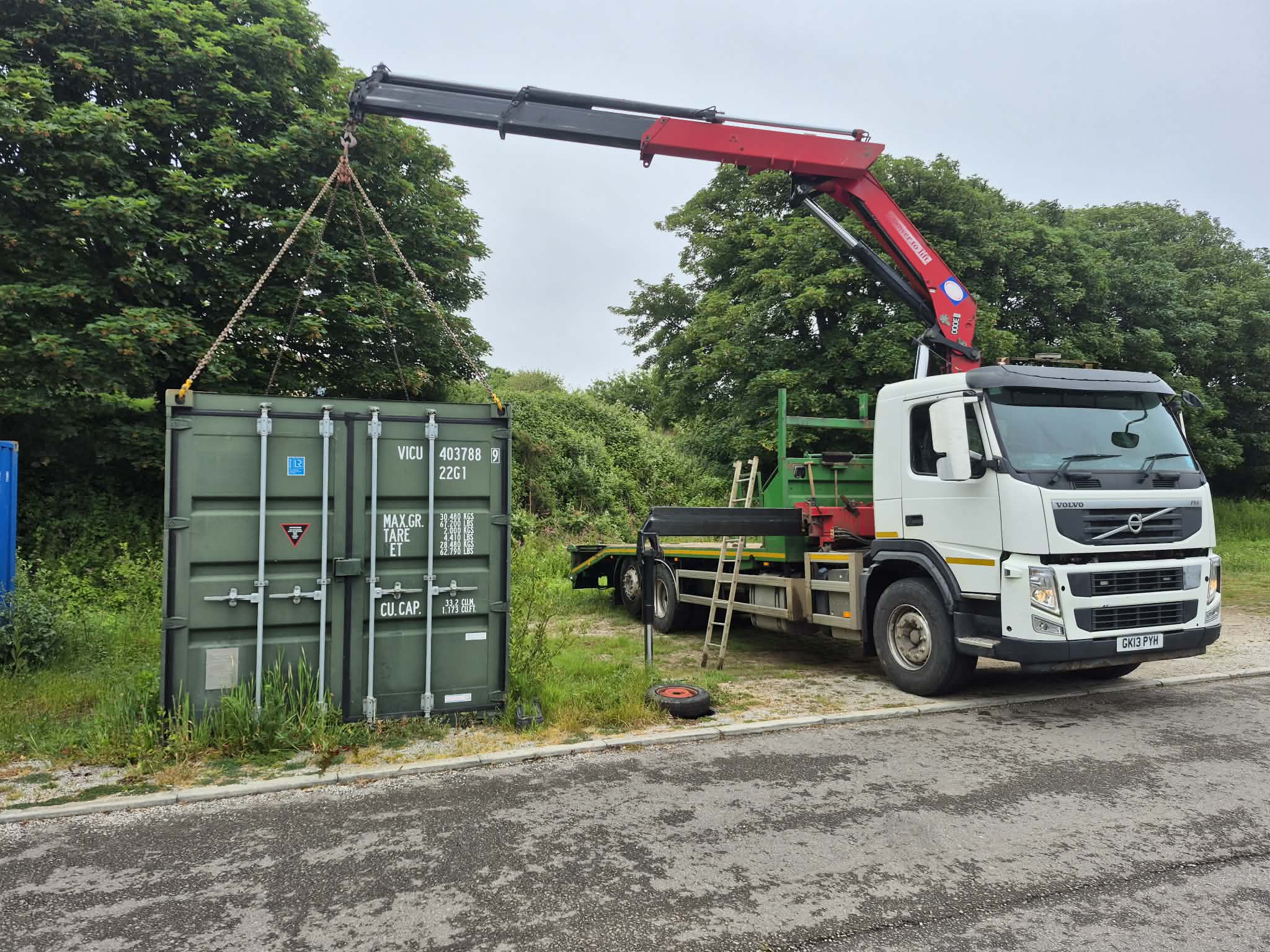 A 20ft shipping container hanging from the hiab crane on chains