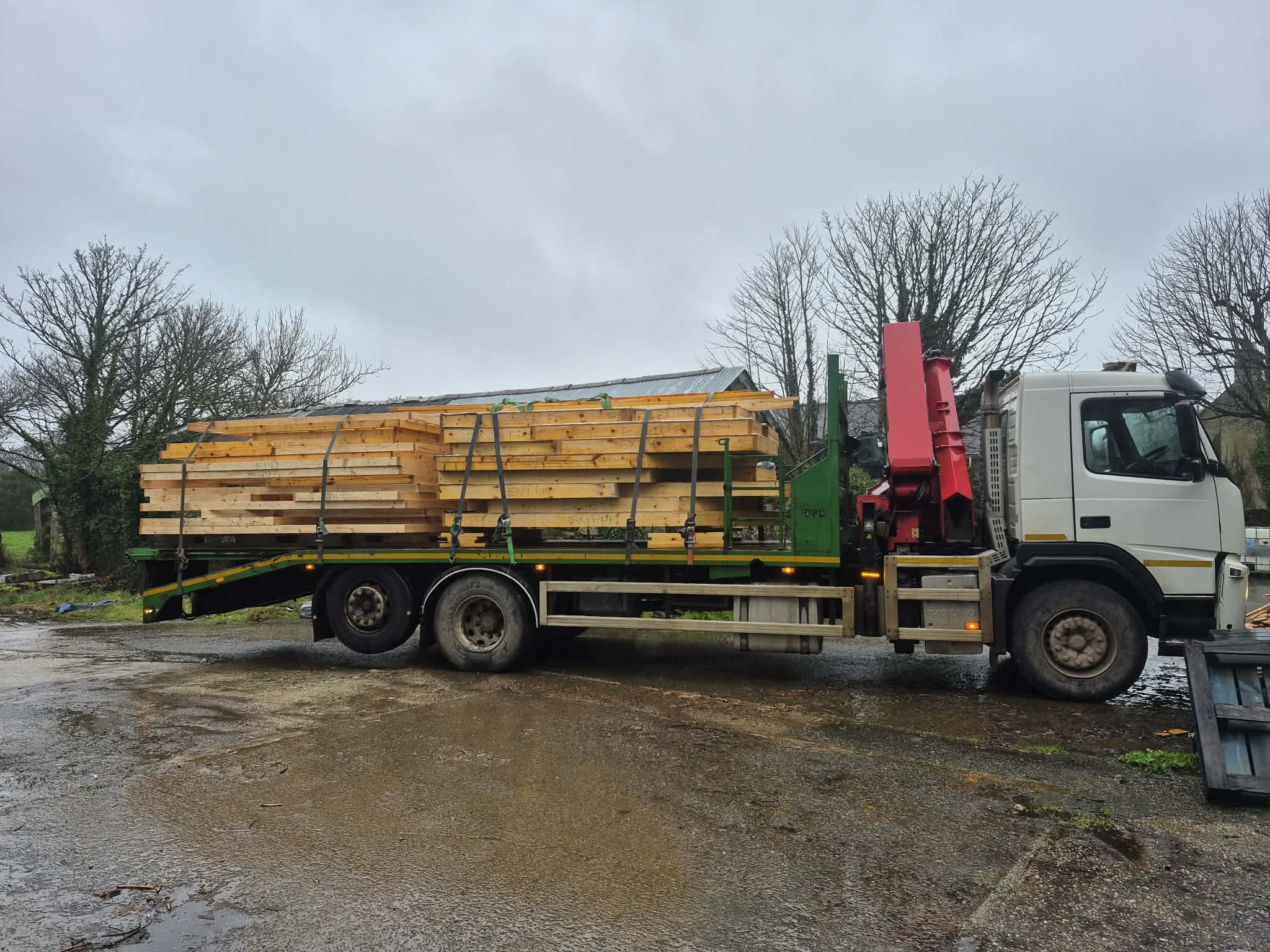 A load of new cut timber strapped down on the flatbed